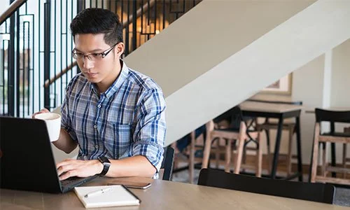 man at a library using his laptop