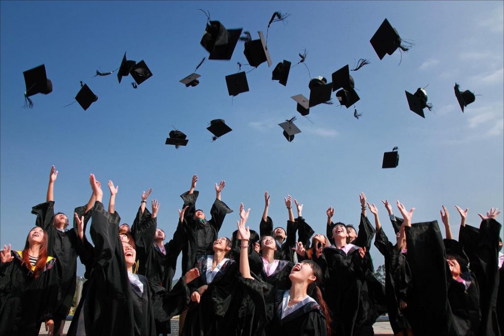 graduates throwing their caps