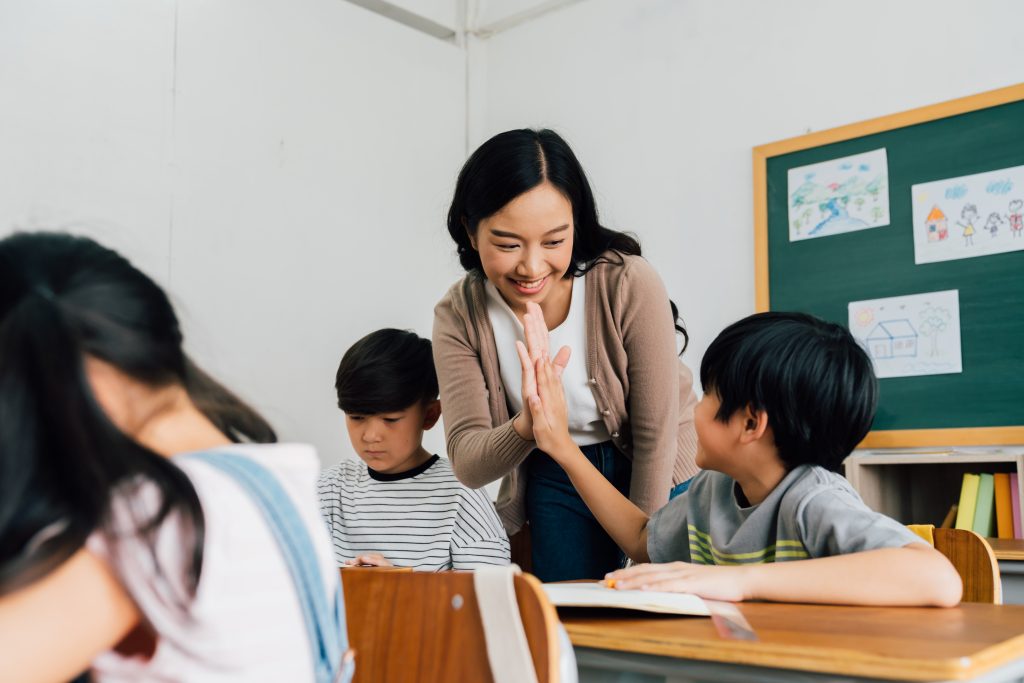 Female teacher doing a high five with a student