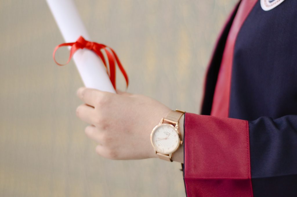 person holding a graduation diploma