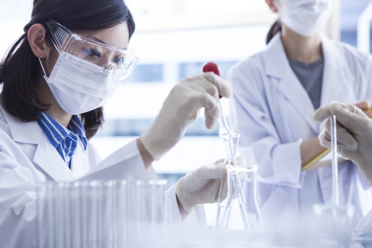 woman in a lab gown doing an experiment