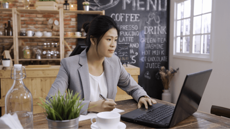 asian businesswoman looking at her laptop