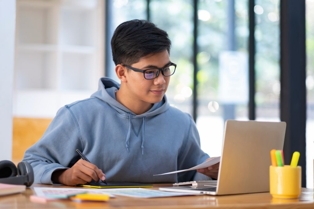  a male IT student using his laptop