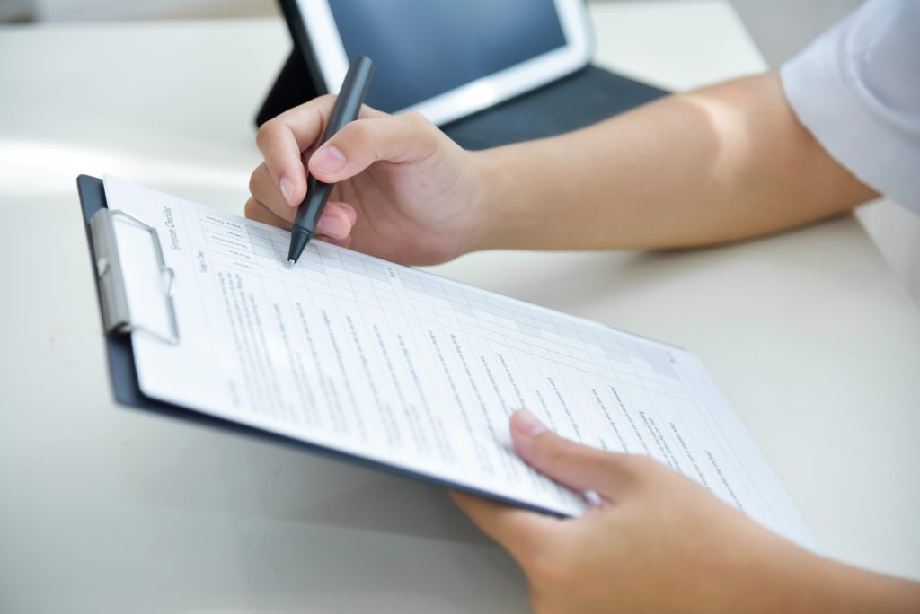 a clinic administrator ticking items on her checklist