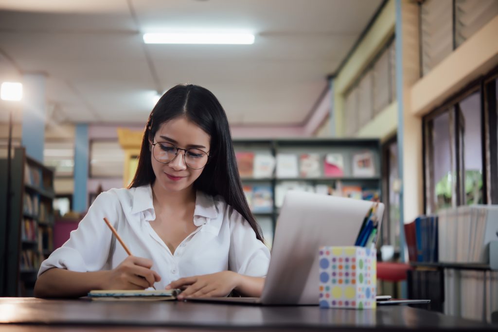 Teacher working with a laptop in a school library