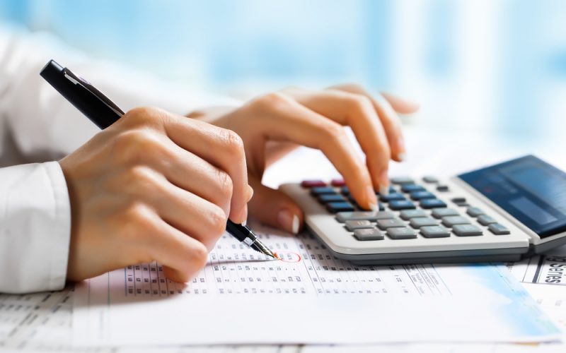 person calculating business profit using a calculator
